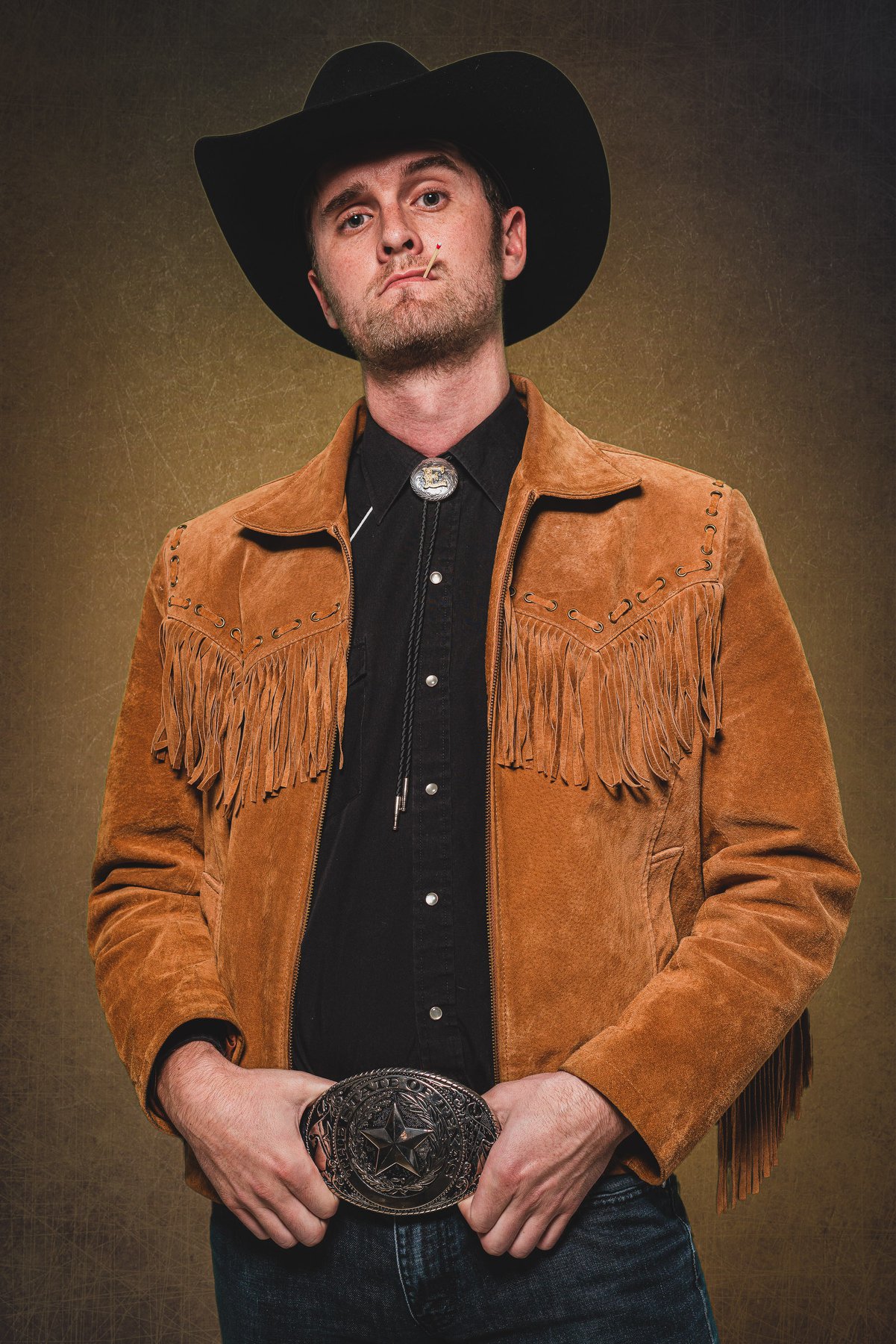 Eric Irish in a cowboy hat, suede jacket, and a Texas belt buckle